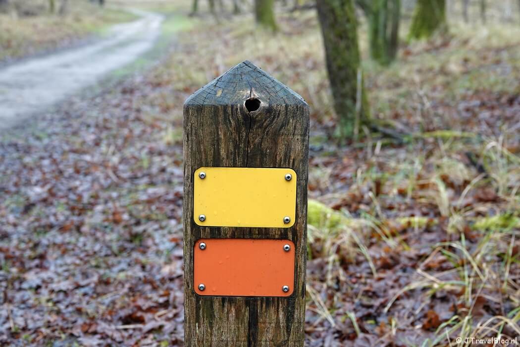 Geel/oranje routepaaltje tijdens de gele wandelroute Oranjekom vanaf ingang Oase in de Amsterdamse Waterleidingduinen