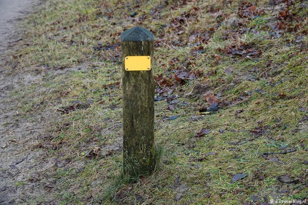Gele routepaaltje tijdens de gele wandelroute Oranjekom vanaf ingang Oase in de Amsterdamse Waterleidingduinen