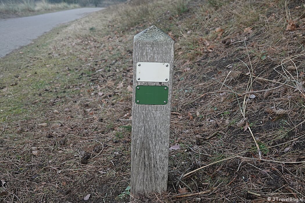 Groen en wit routepaaltje tijdens de Trage Tocht Amsterdamse Waterleidingduinen